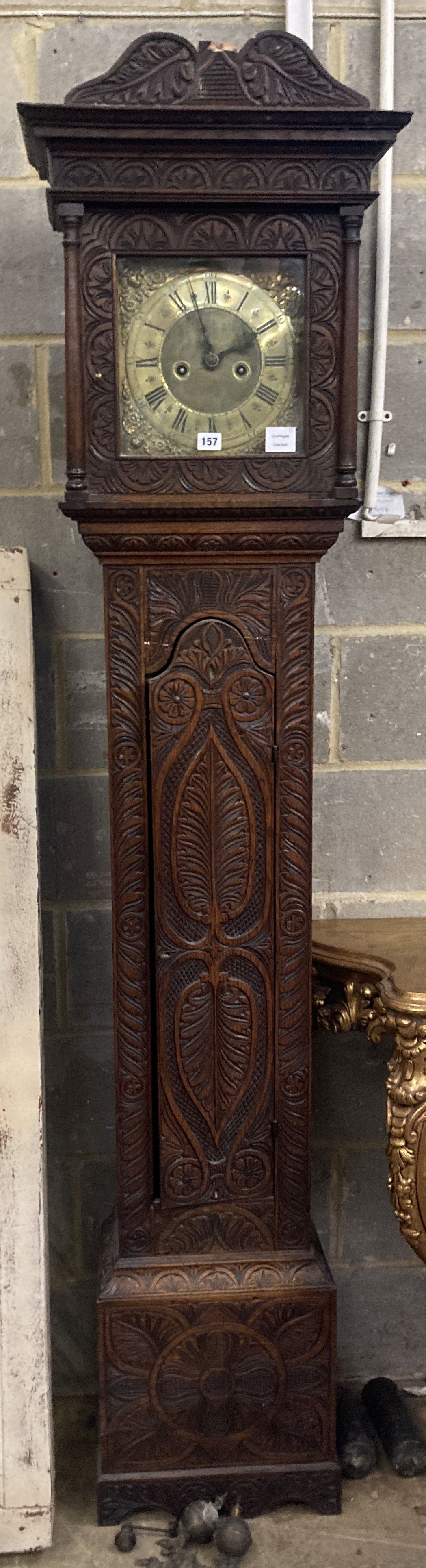 Simon Worley of Starton - an early 18th century 8 day longcase clock, contained in a later carved oak vase, height 210cm